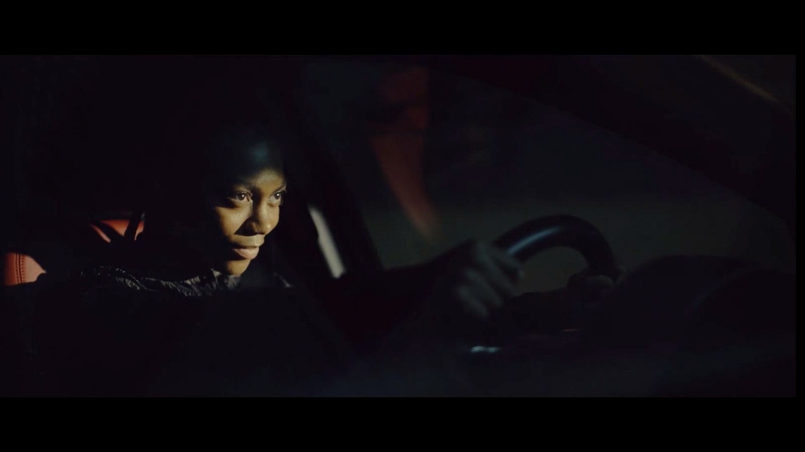 a woman driving a car in the dark