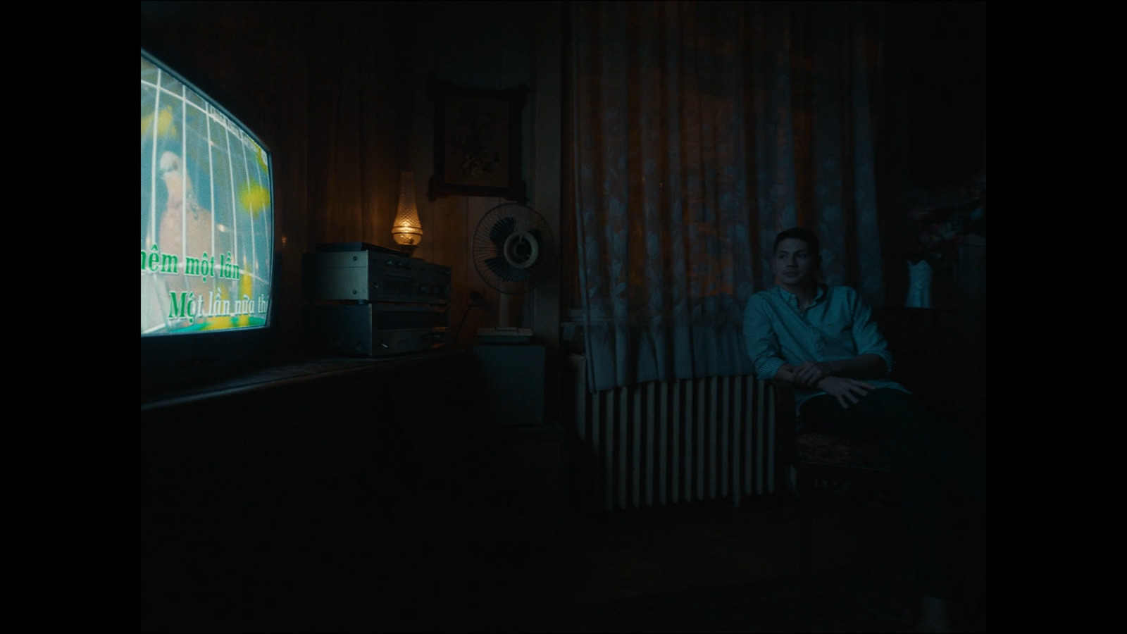 a man sitting in a chair in front of a flat screen tv