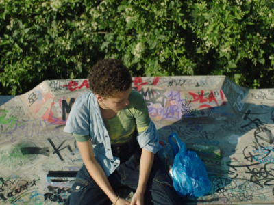 a young boy is sitting on a skateboard ramp