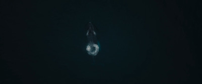 a person floating in the water in the dark