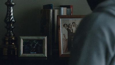 a man looking at a picture on a shelf