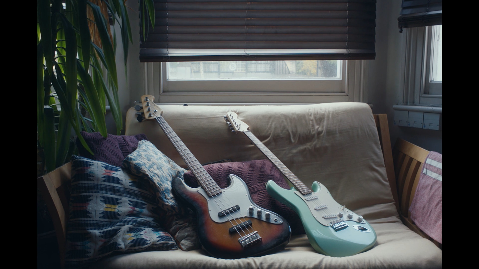 a couple of guitars sitting on top of a couch