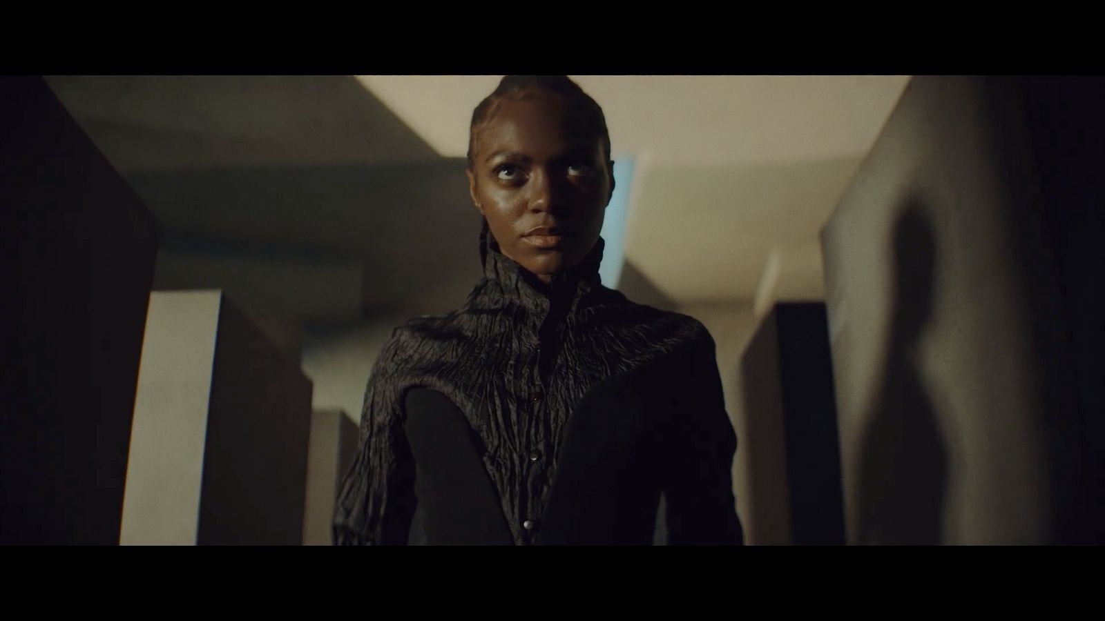 a woman standing in a hallway in a dark room