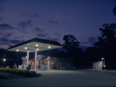 a gas station at night with lights on