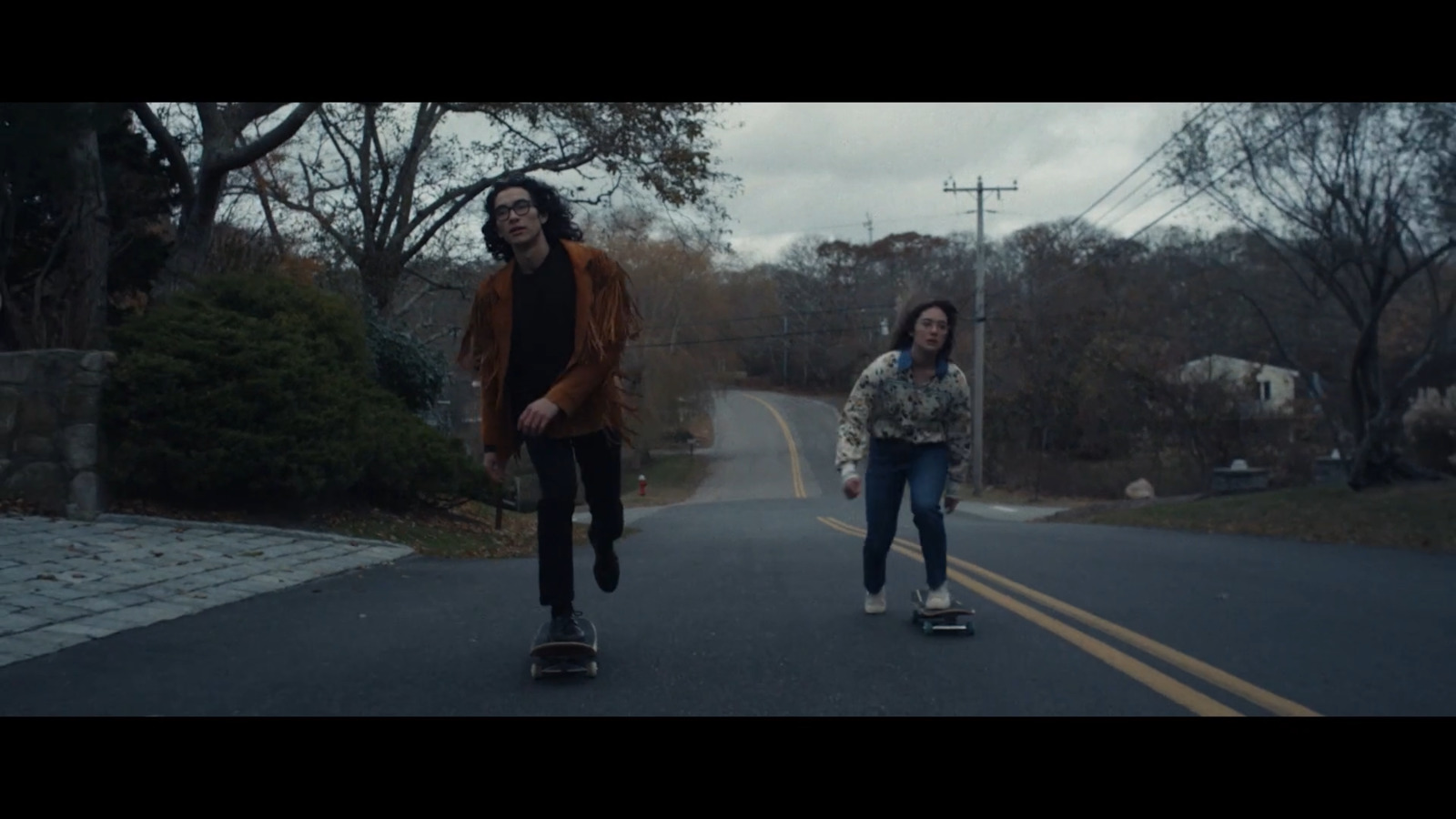 a couple of people riding skateboards down a street