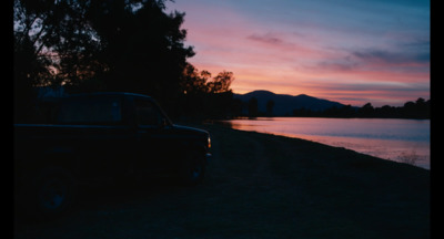 a truck parked next to a body of water