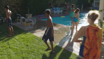 a group of people standing around a swimming pool