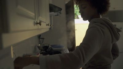 a woman standing in a kitchen next to a sink