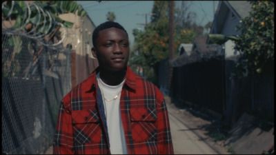 a man standing in front of a fence