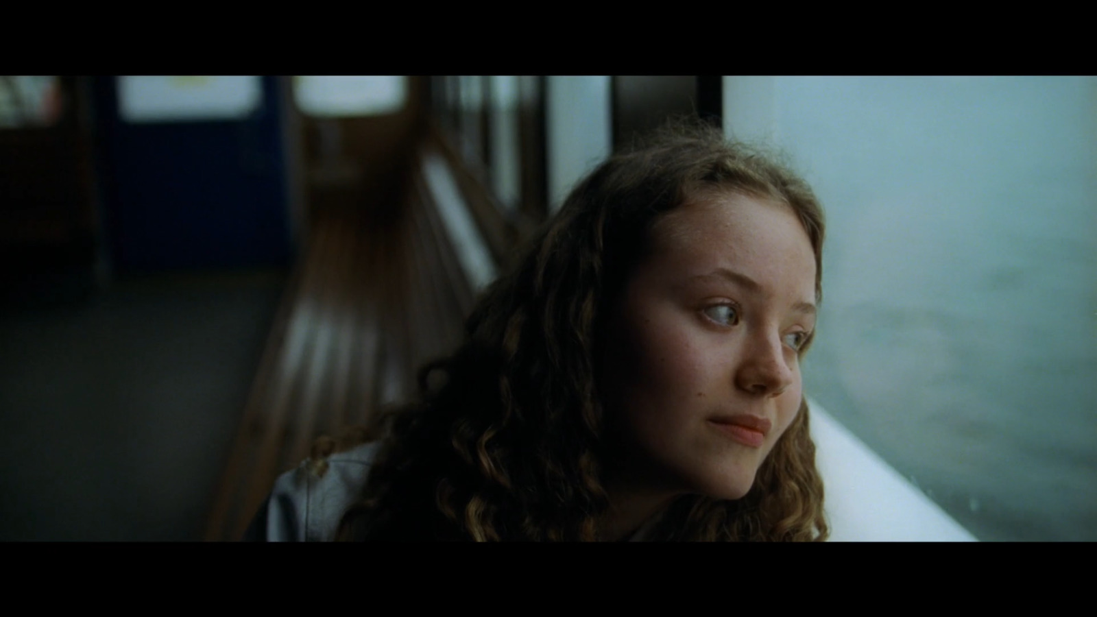 a young girl looking out a window at something