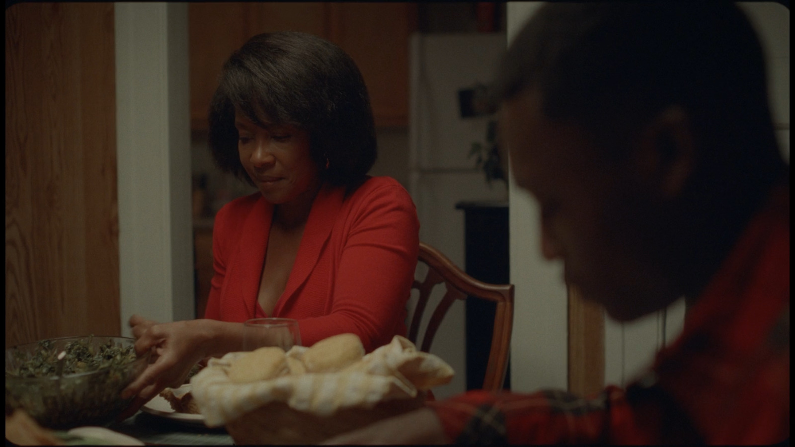 a woman sitting at a table with a bowl of food