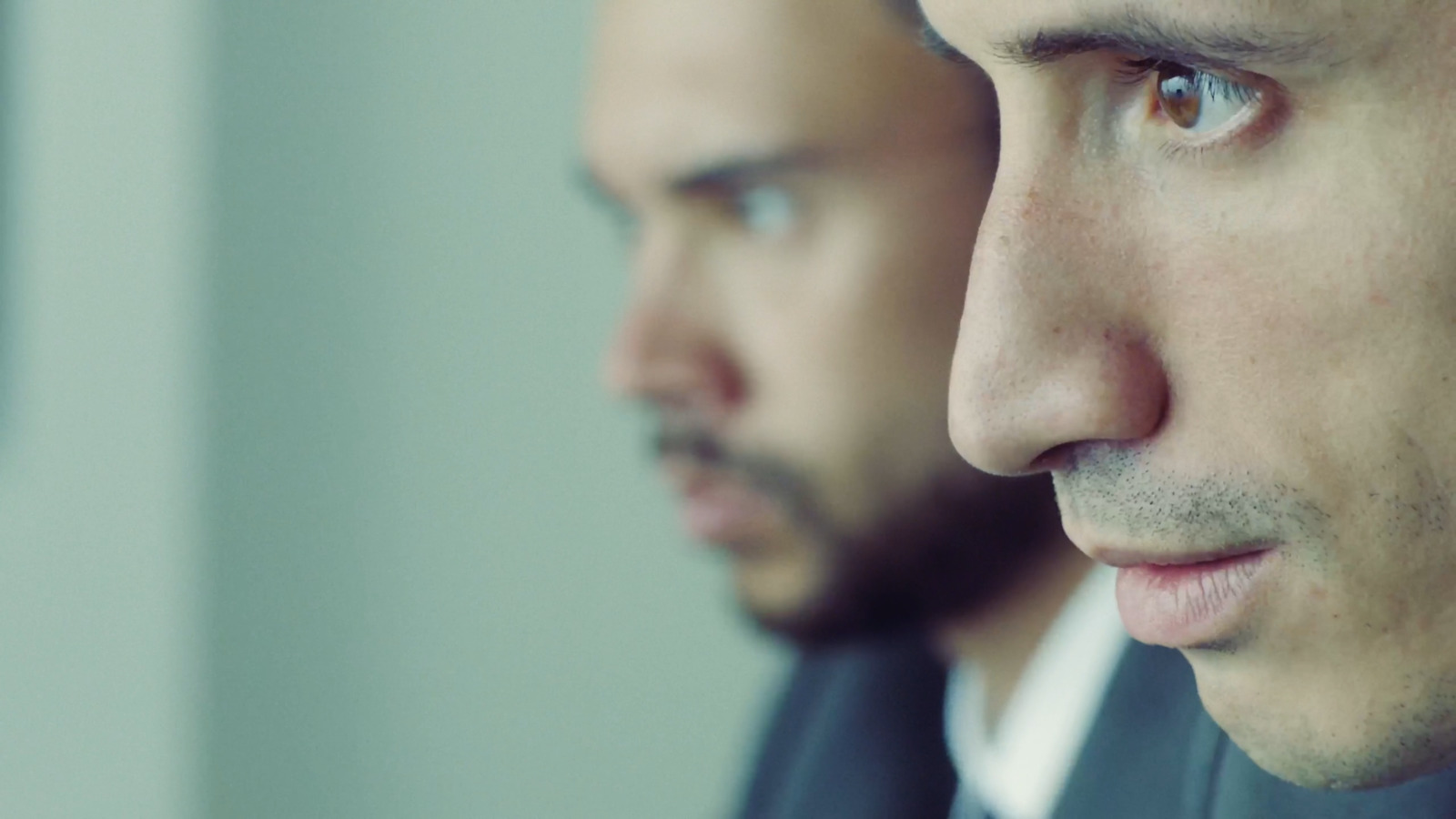 a close up of a person wearing a suit and tie