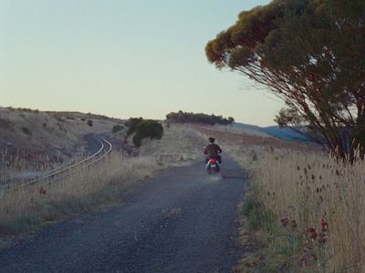 a person riding a motorcycle down a dirt road