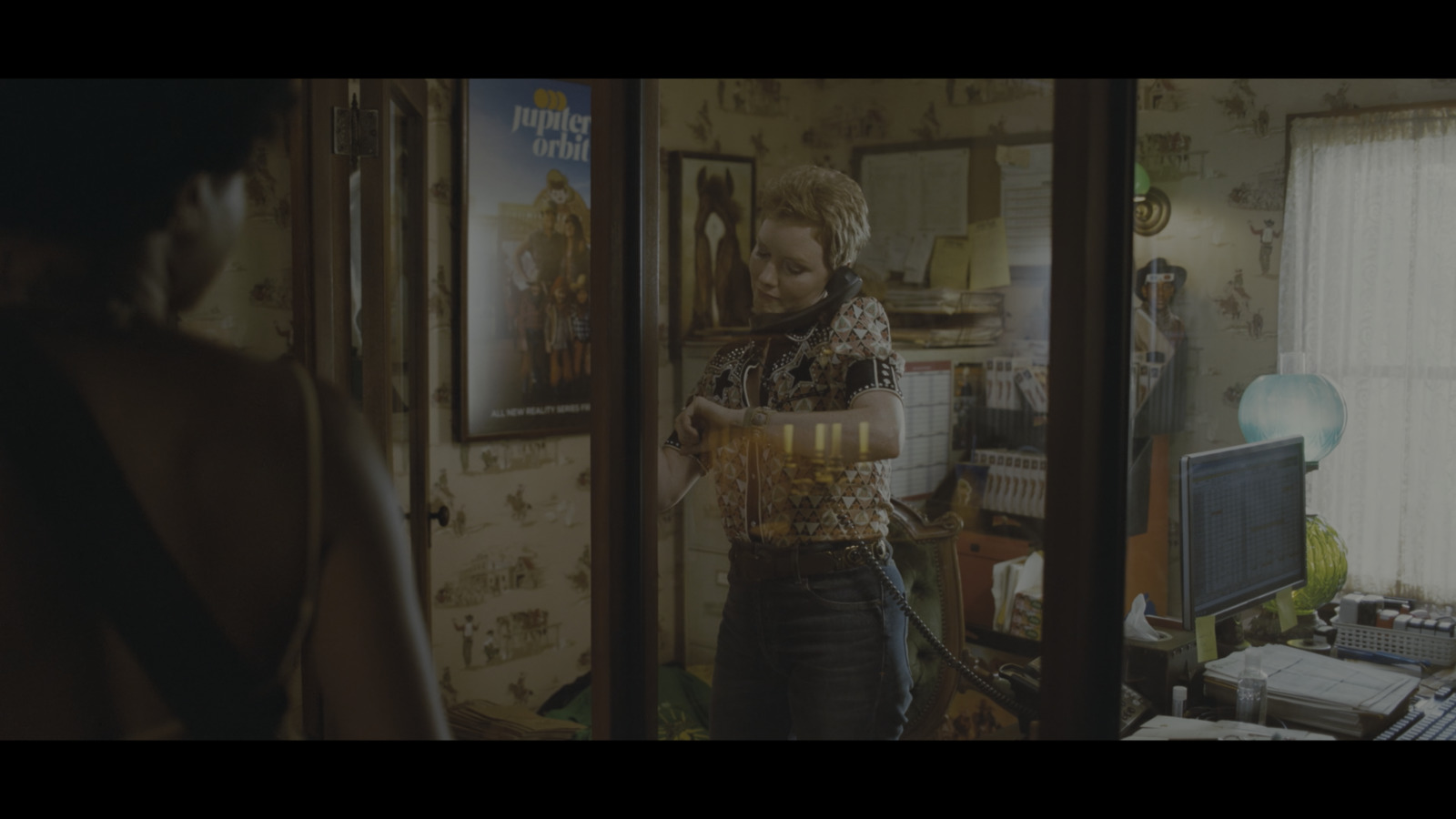 a woman standing in front of a mirror holding a glass