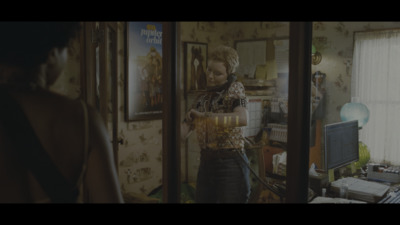 a woman standing in front of a mirror holding a glass