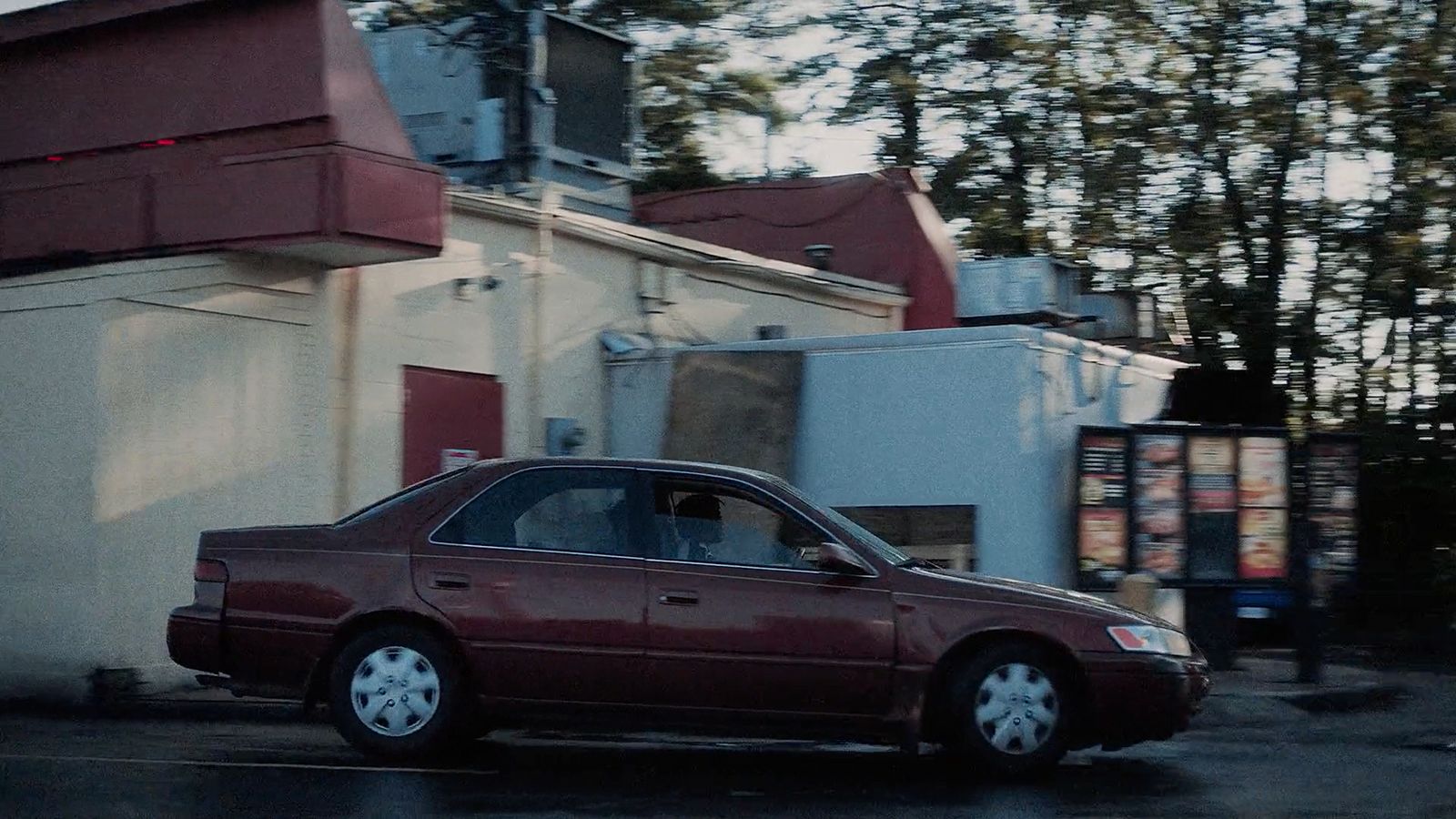 a red car parked in front of a building