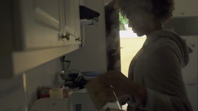 a woman standing in a kitchen preparing food