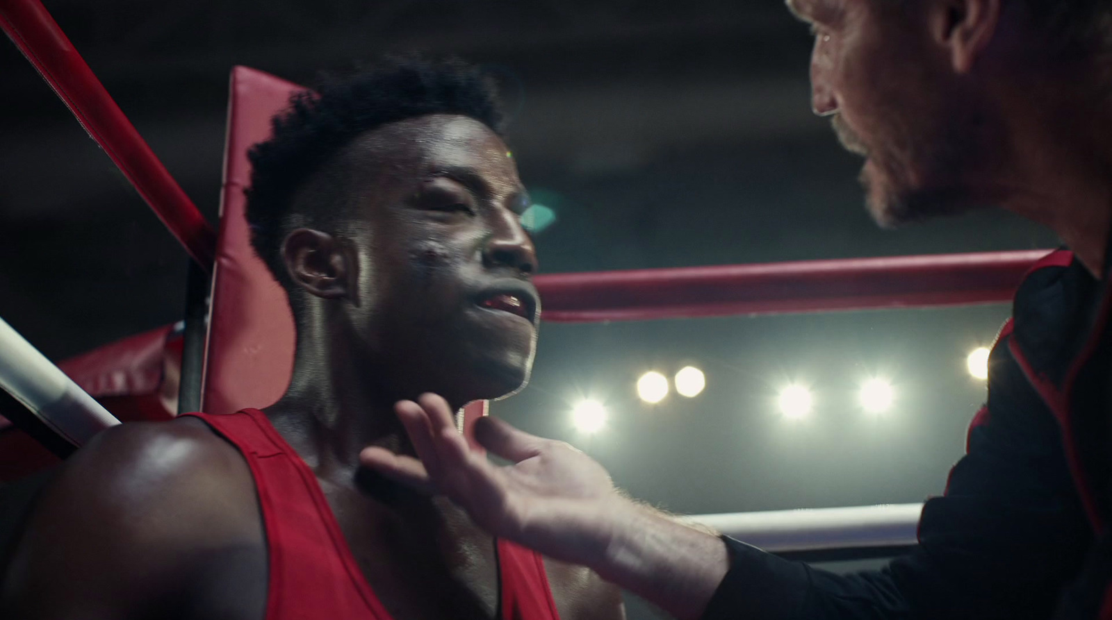 a man standing next to another man in a boxing ring