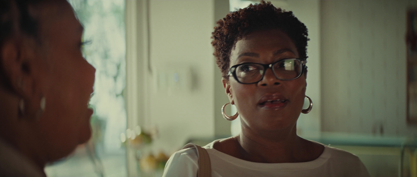 a woman with glasses talking to another woman