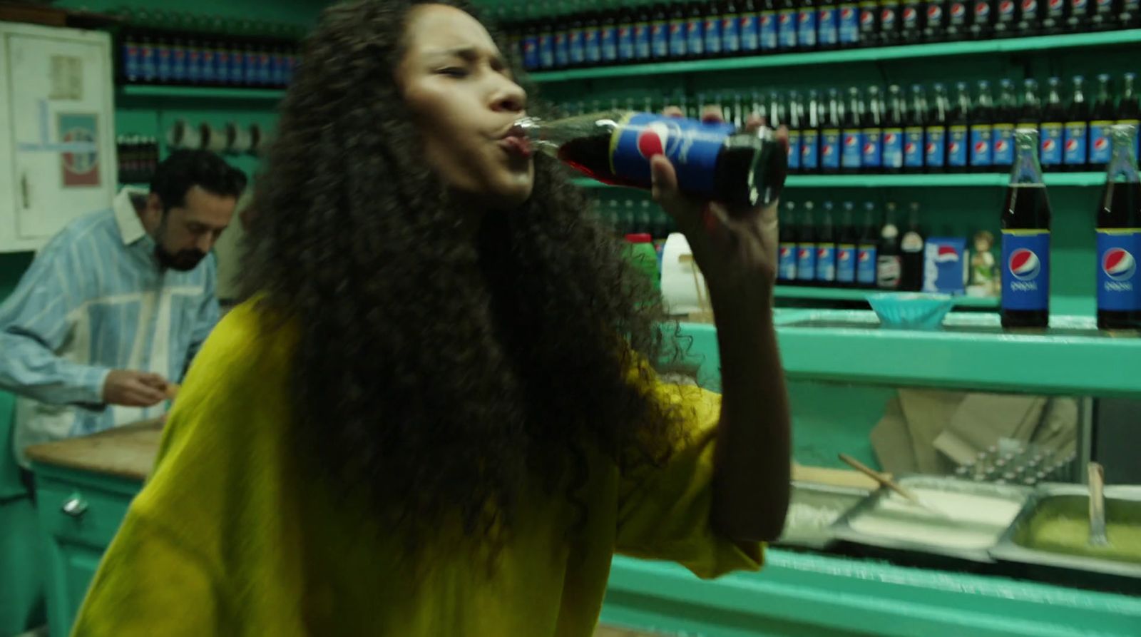 a woman with long hair drinking from a can