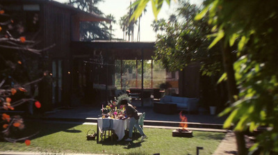 a group of people sitting around a table on top of a lush green field