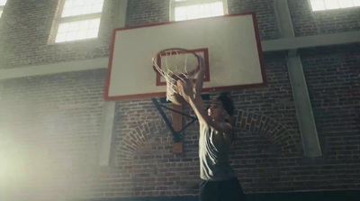 a man holding a basketball up to a basketball hoop