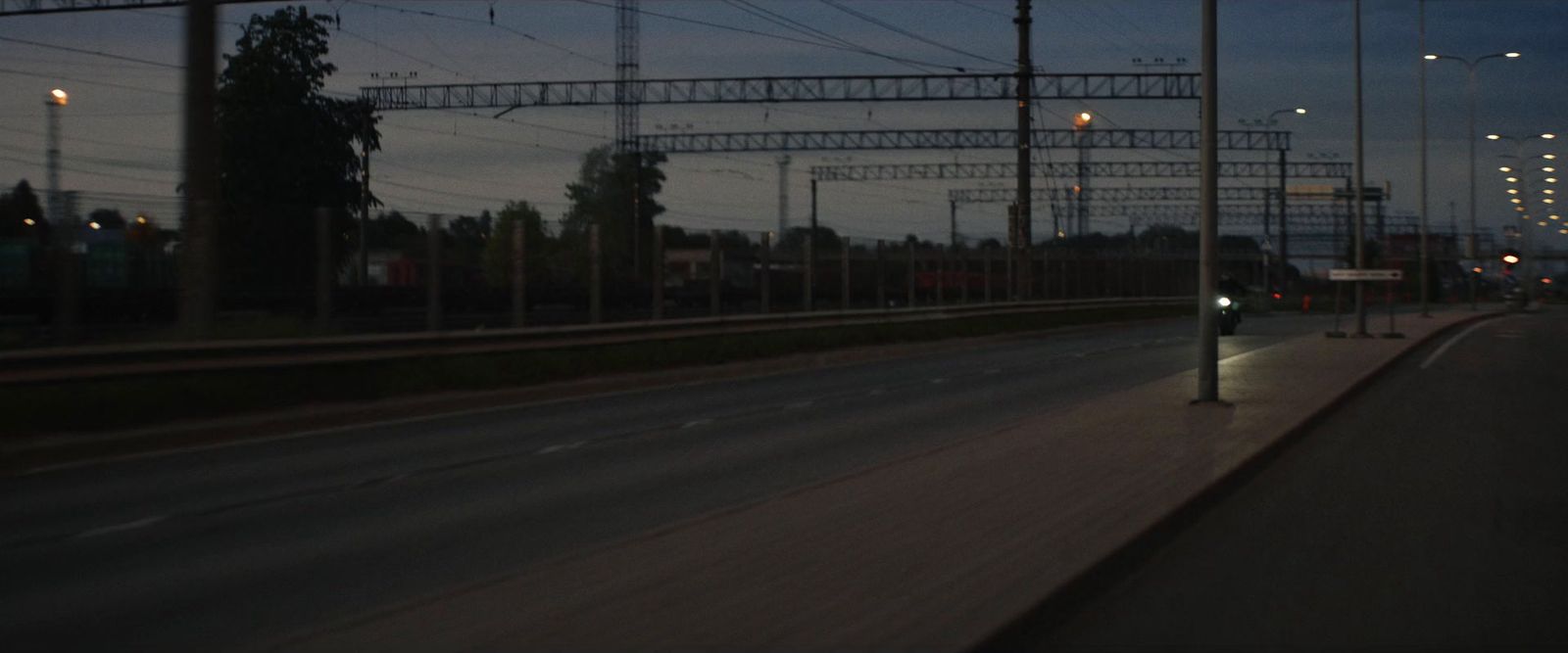 a city street at night with lots of power lines