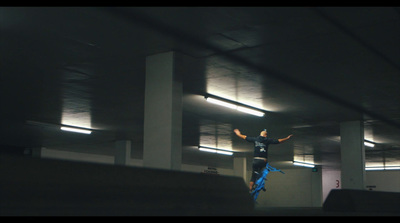 a person jumping in the air in a parking garage