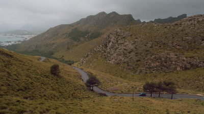 a car driving down a winding road in the mountains