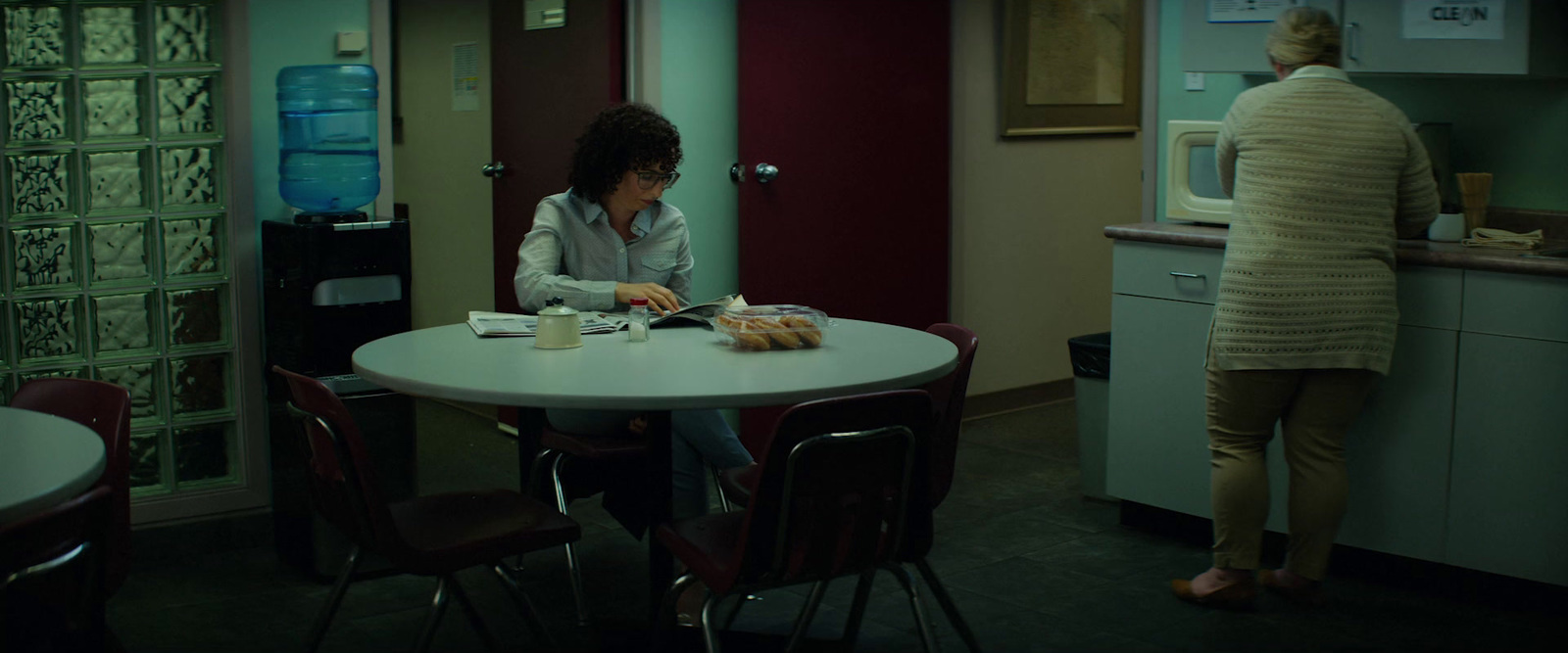 a woman sitting at a table in a kitchen