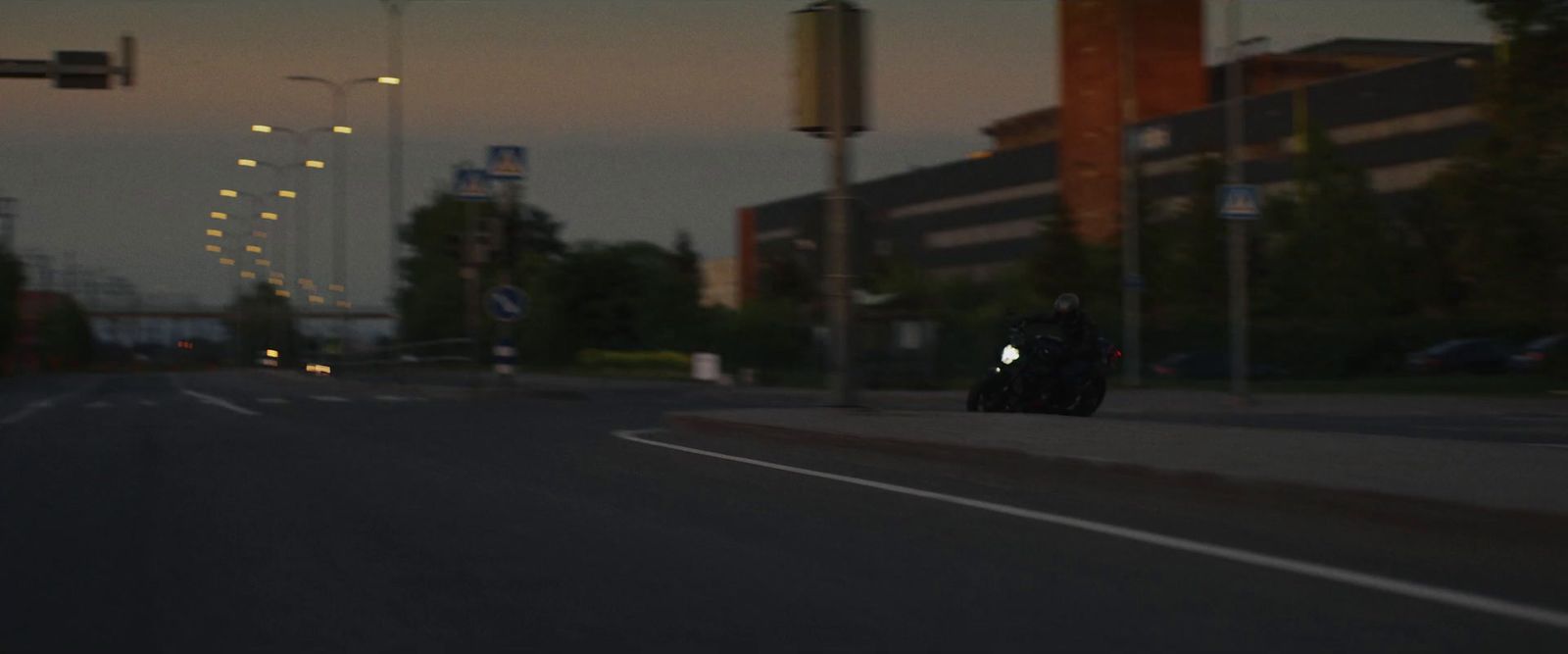 a person riding a motorcycle down a street at night