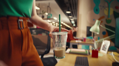 a woman is holding a cup of coffee in an office