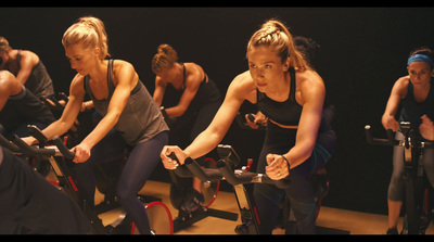 a group of women riding stationary bikes in a gym