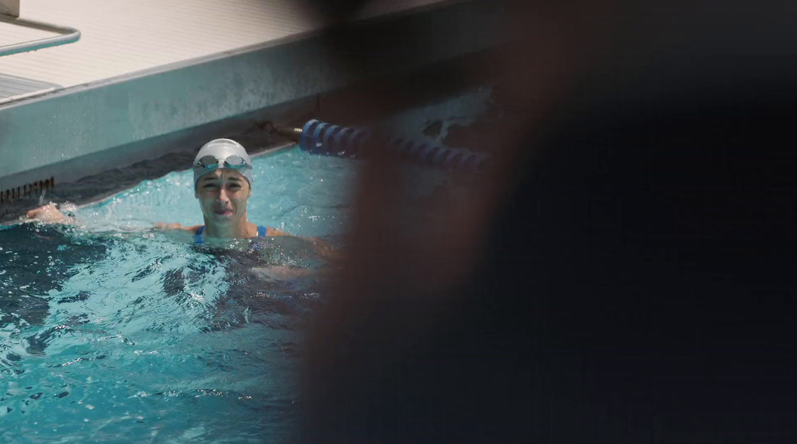 a man swimming in a pool wearing a swimming cap