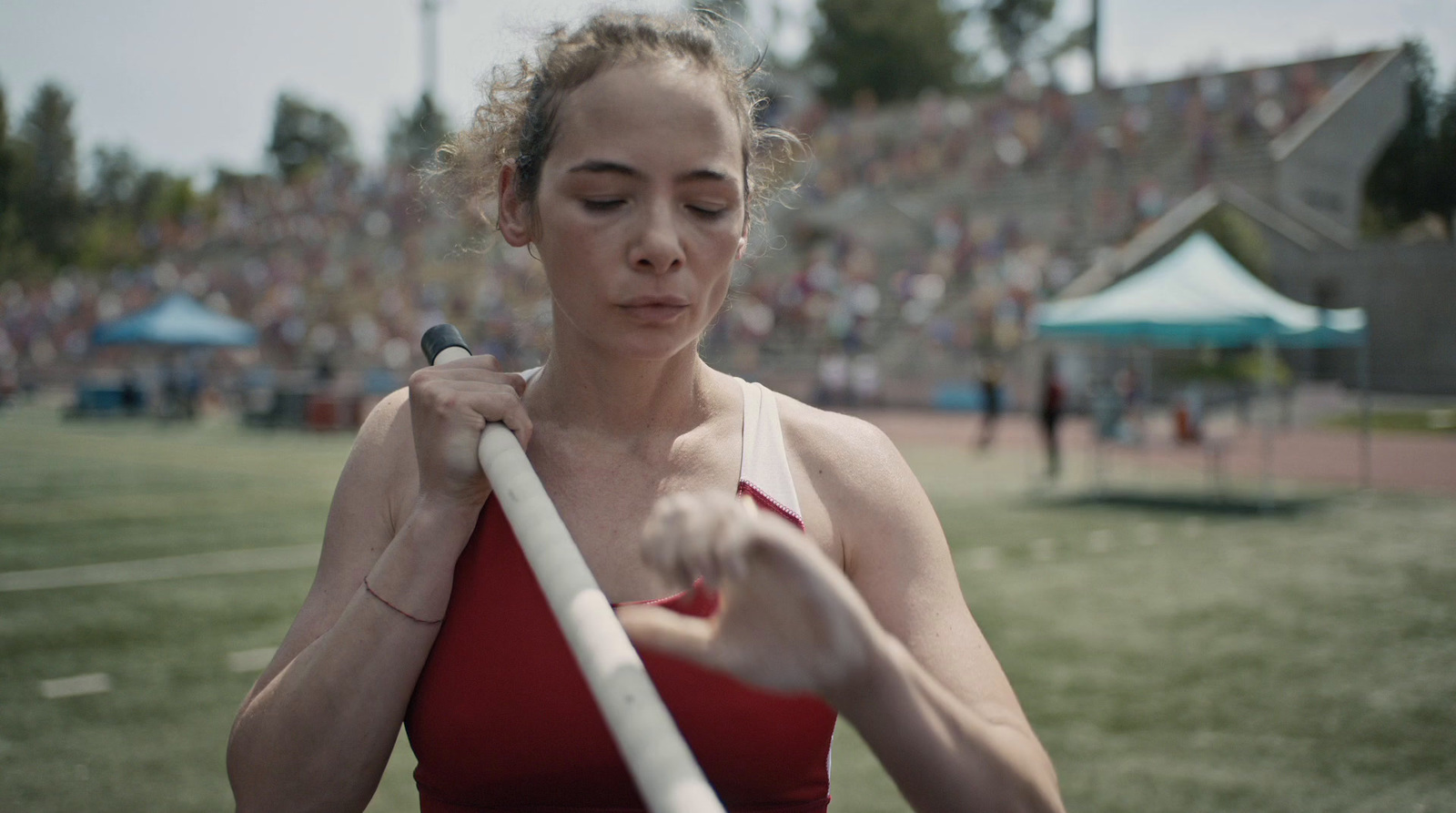 a woman in a red top holding a white pole