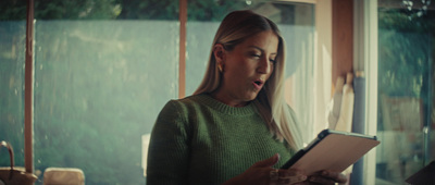 a woman standing in front of a window holding a tablet