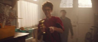 a man and a woman in a kitchen holding a gold ball