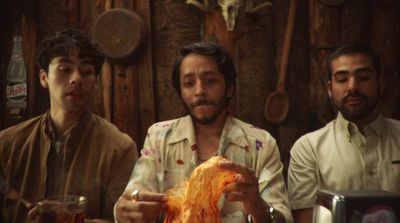 a group of men sitting around a table eating food