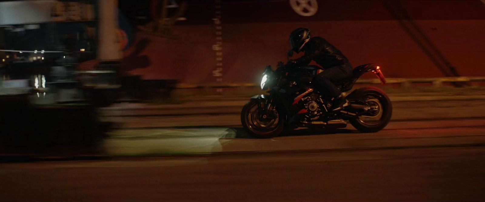 a man riding a motorcycle down a street at night