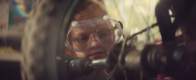 a woman wearing goggles looking through a wheel