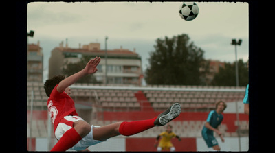 a man kicking a soccer ball on top of a field