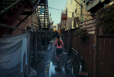 a woman walking down a narrow alley way