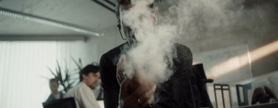 a man standing in a room with smoke coming out of his mouth