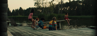 a group of young children sitting on a dock