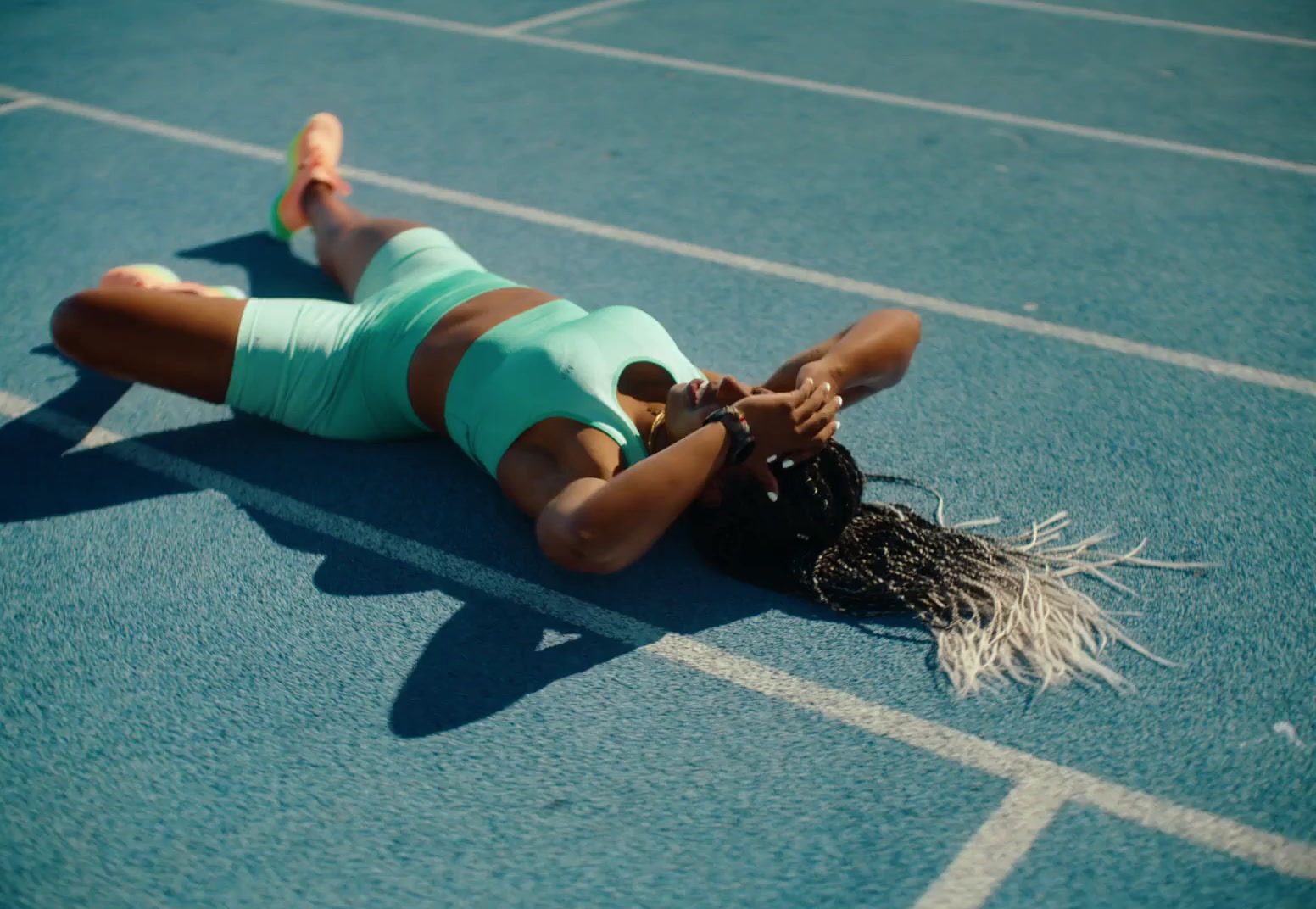 a woman laying on the ground on a track