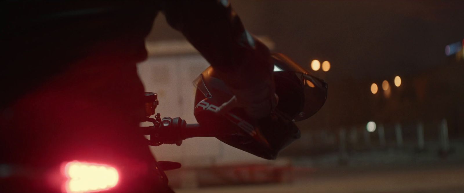 a close up of a person riding a motorcycle at night