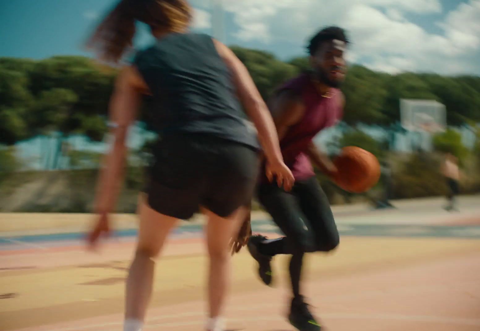 a man and a woman playing basketball on a court