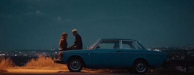 a blue car parked on the side of a road