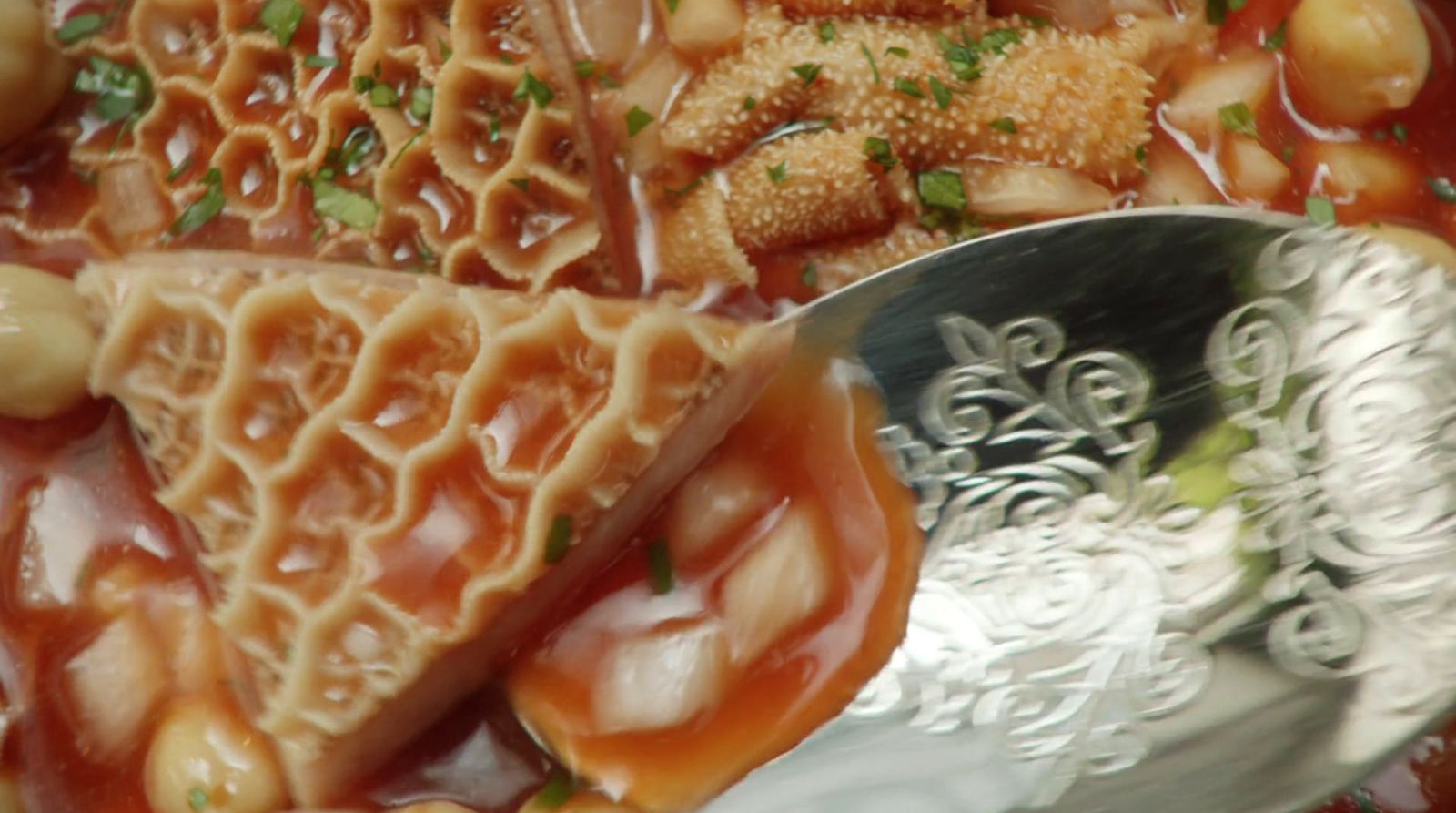 a silver spoon sitting on top of a bowl of food