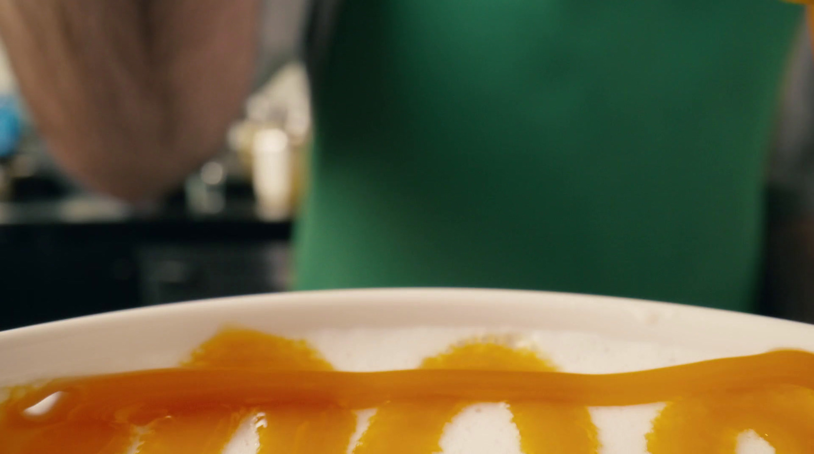 a person is pouring syrup into a cup of coffee